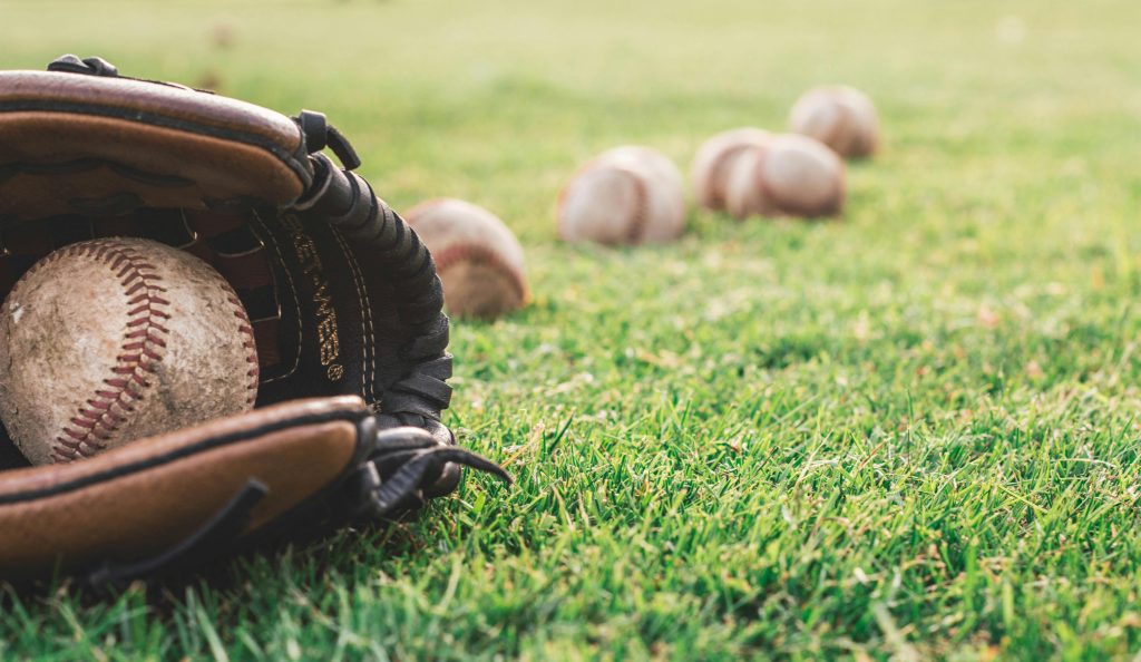 Softball glove and balls over a grass field